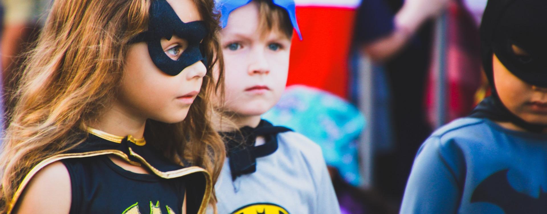 Niña y niño disfrazados de Batwoman y Batman
