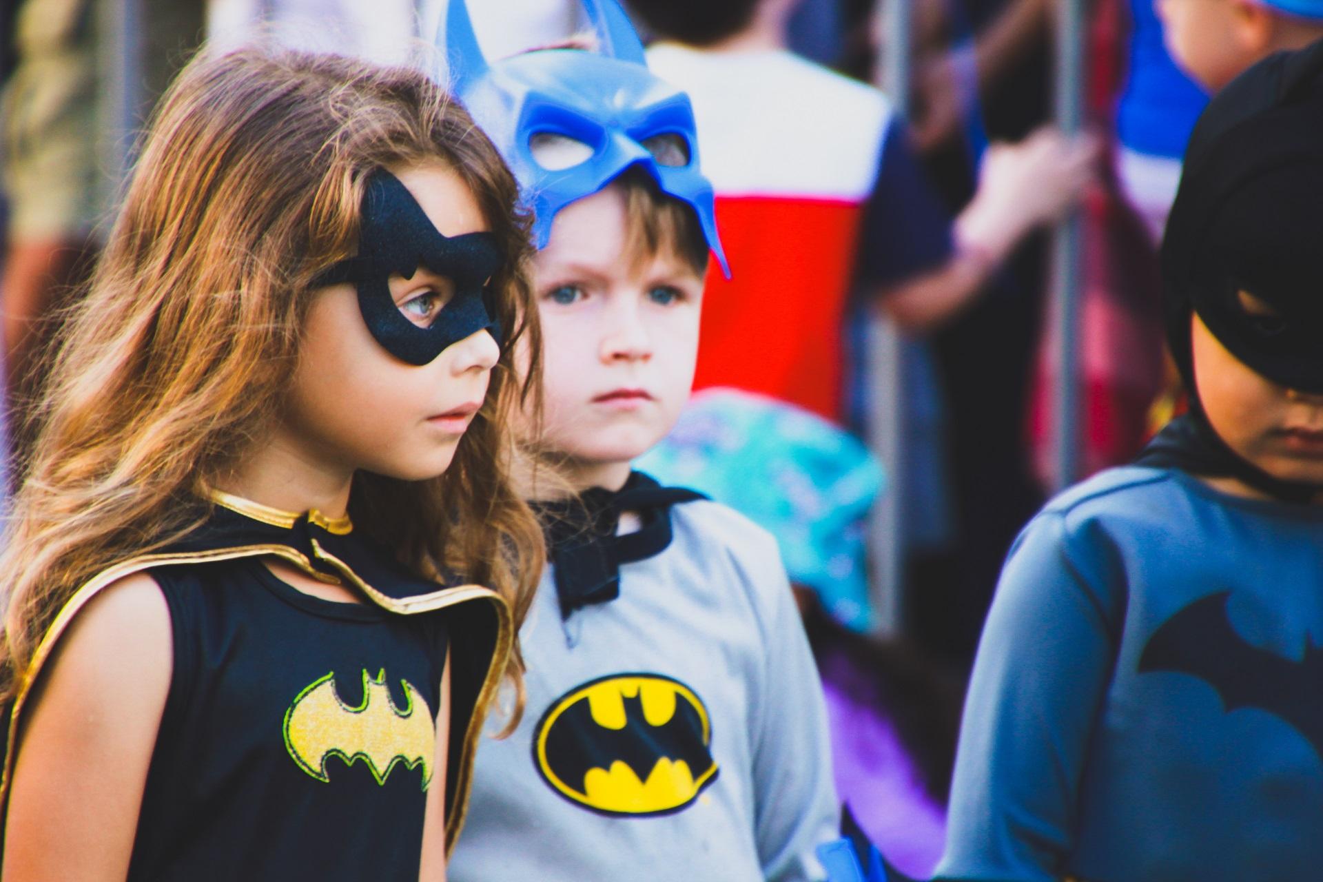 Niña y niño disfrazados de Batwoman y Batman